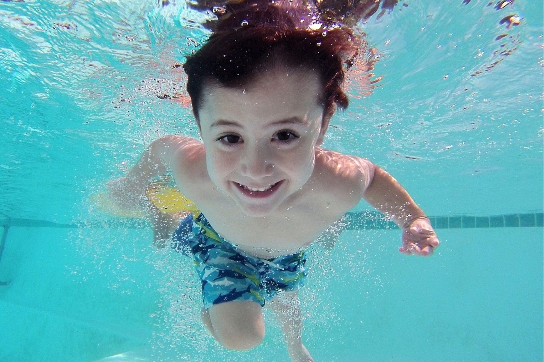 Boy swimming underwater with eyes open