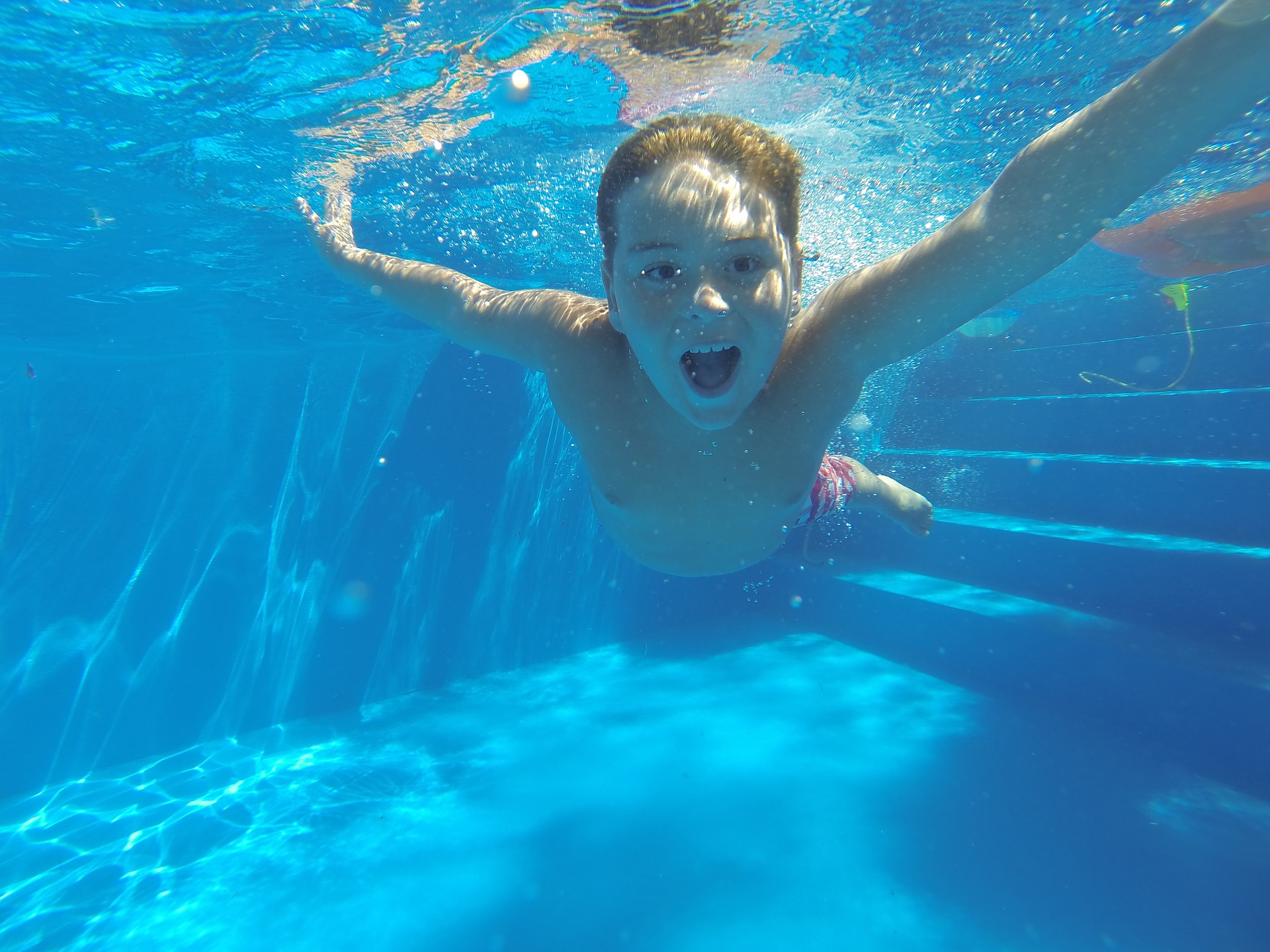 Young Boy Swimming Underwater In A pool