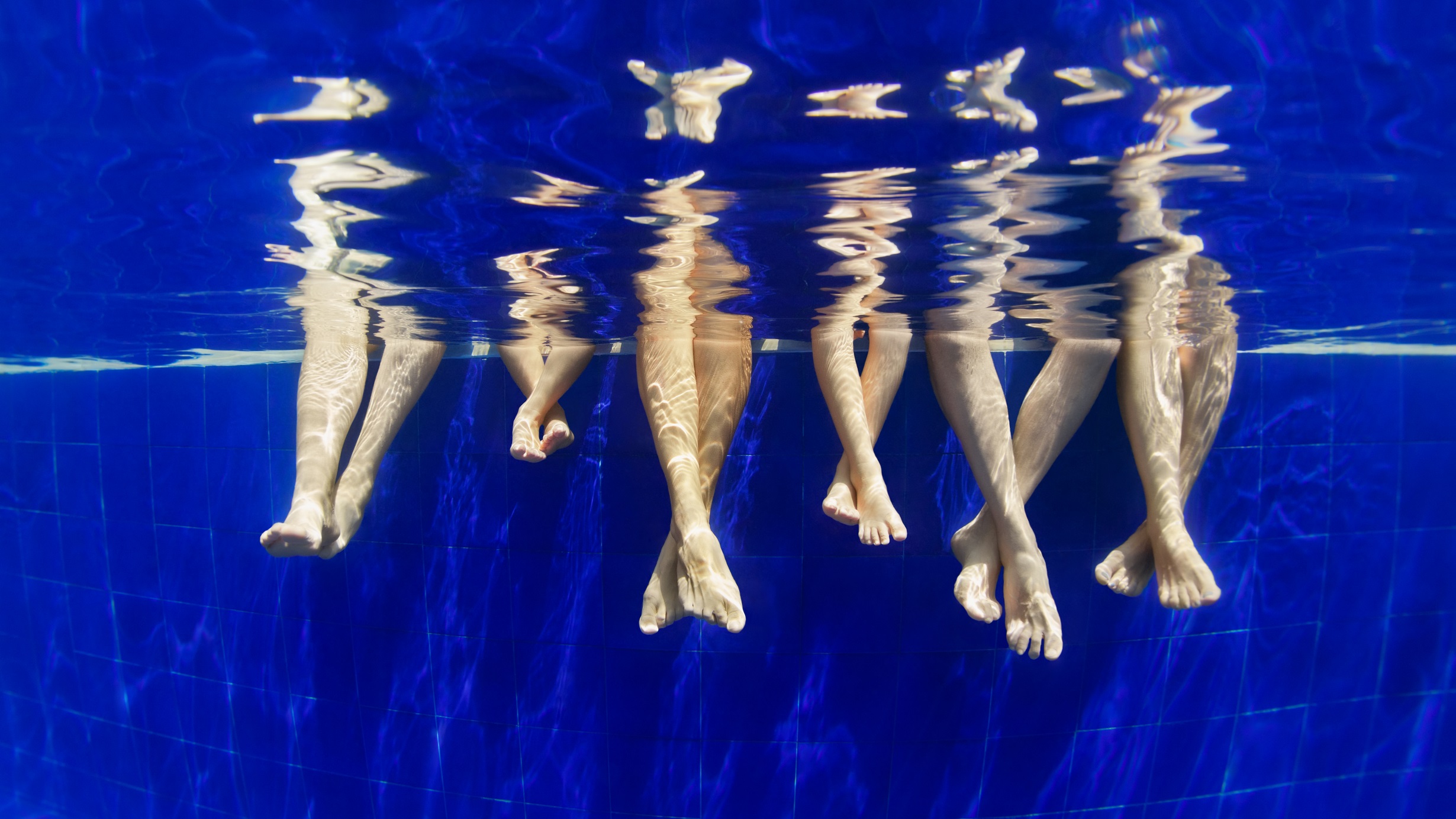 Bare feet dipping into the pool water