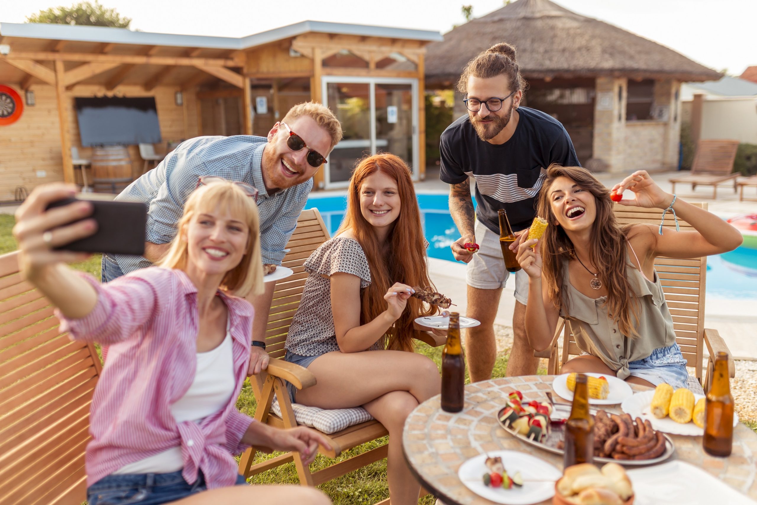 Friends taking a selfie at backyard barbecue party